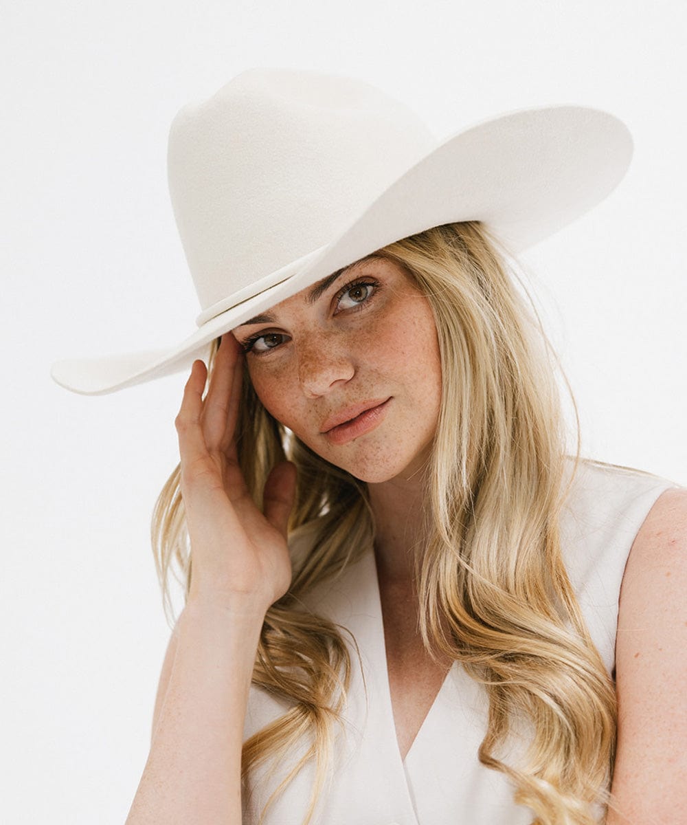 Woman wearing a white hat with a plain background