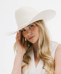 Woman wearing a white hat with a plain background