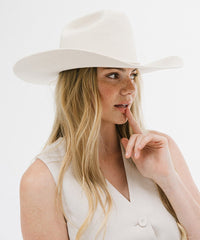 Woman wearing a white hat and white top on a white background