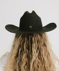 Black cowboy hat worn by a person with long blonde hair on a white background