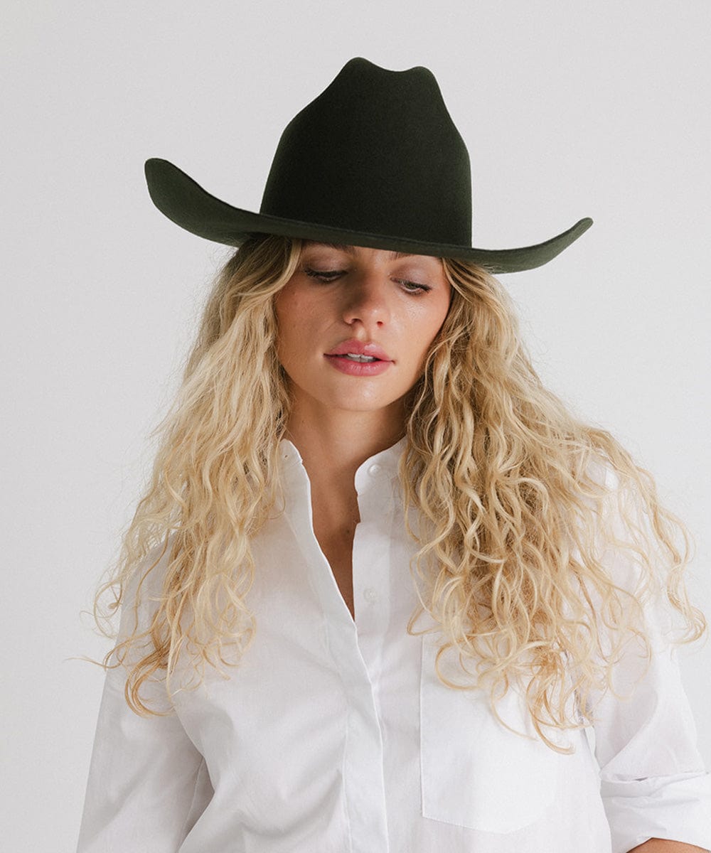 Woman wearing a black cowboy hat against a white background