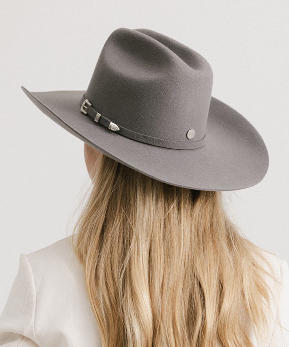 Person wearing a gray fedora hat with a belt on a white background
