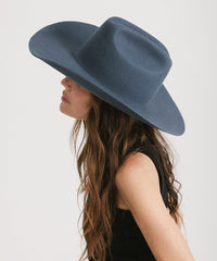 Person wearing a blue wide-brimmed hat on a plain background