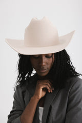 Person wearing a beige cowboy hat against a white background