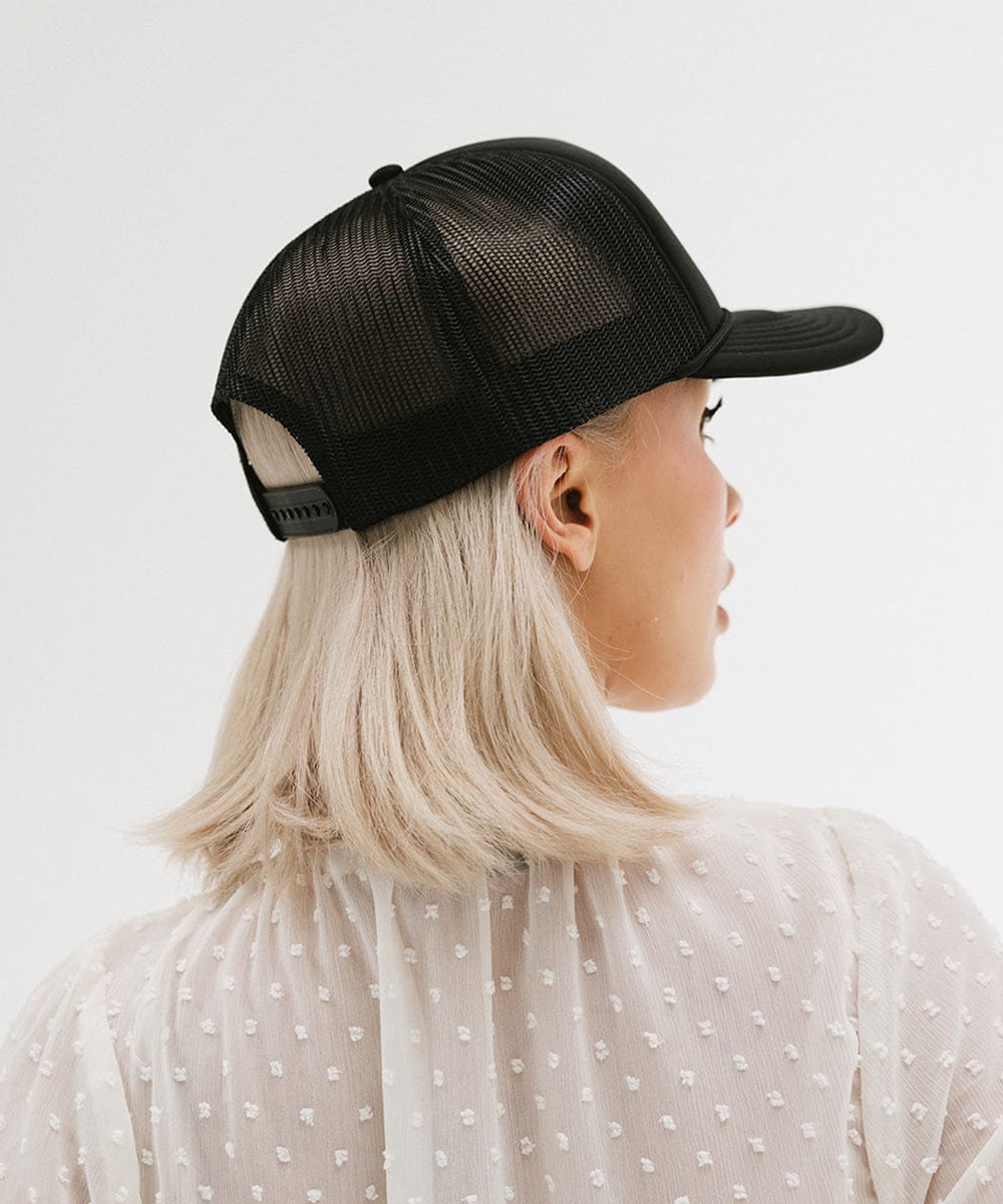 Person wearing a black mesh cap on a white background