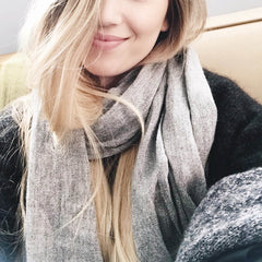 Person wearing a gray scarf with a blurred background