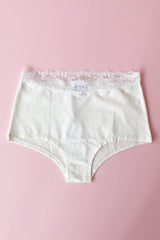 White underwear with lace trim on a pink background