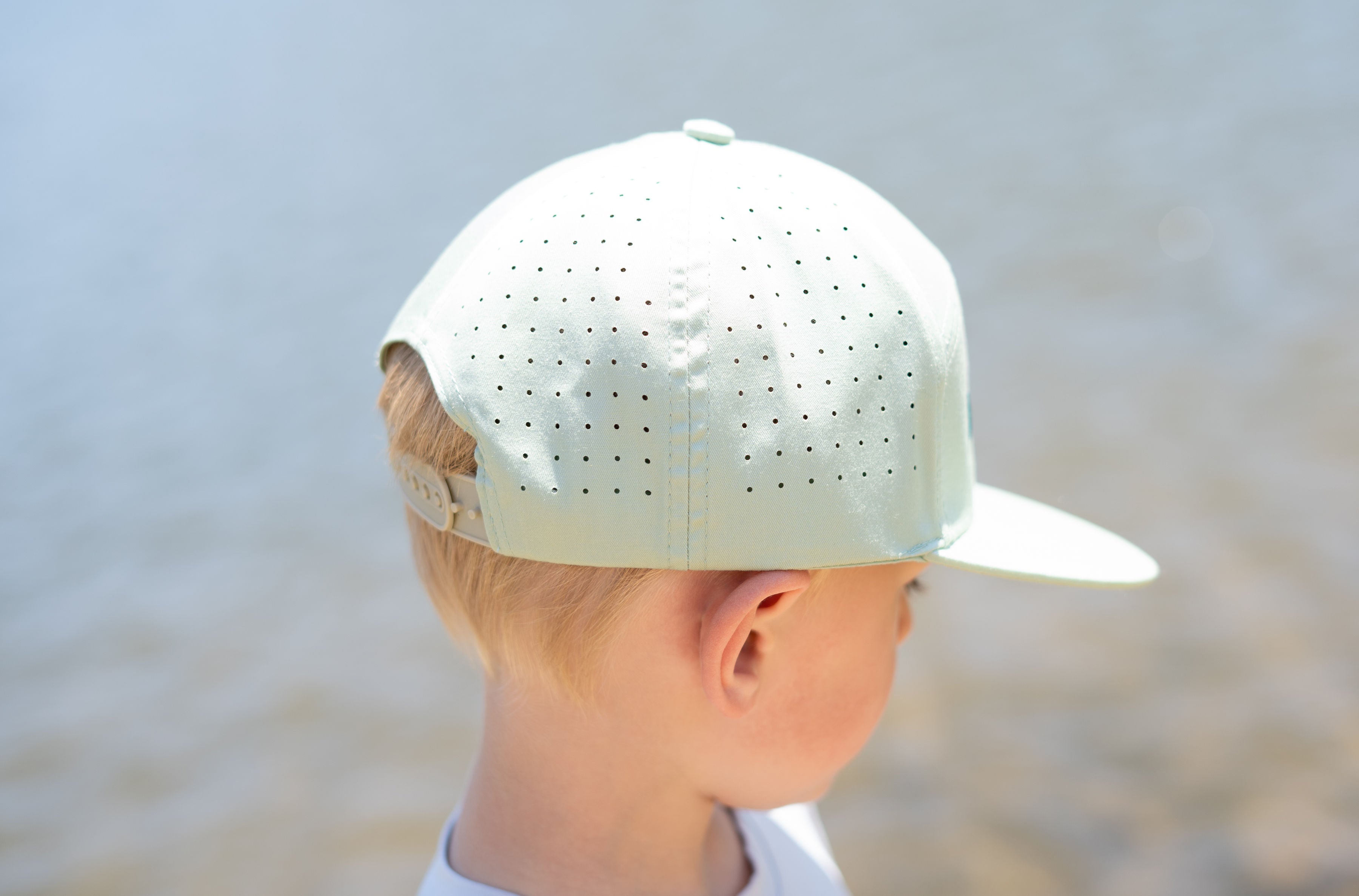 Child wearing a white cap with a blurred background