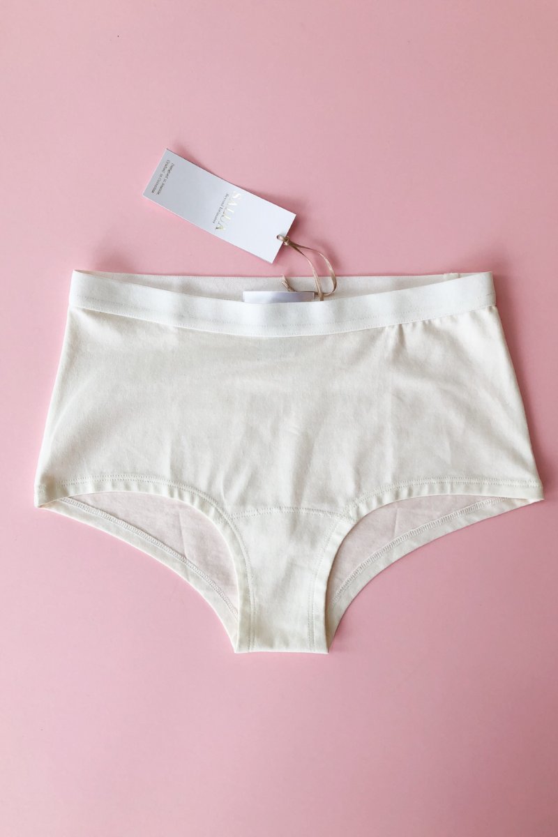 White underwear with a tag on a pink background