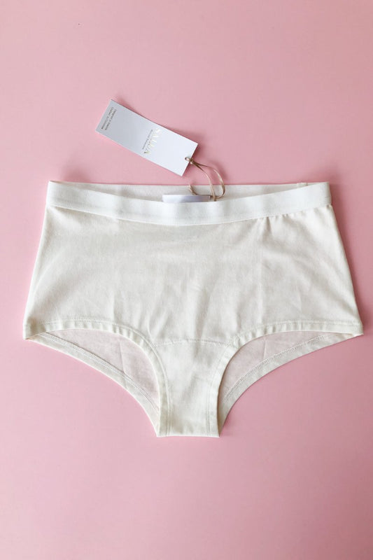 White underwear with a tag on a pink background