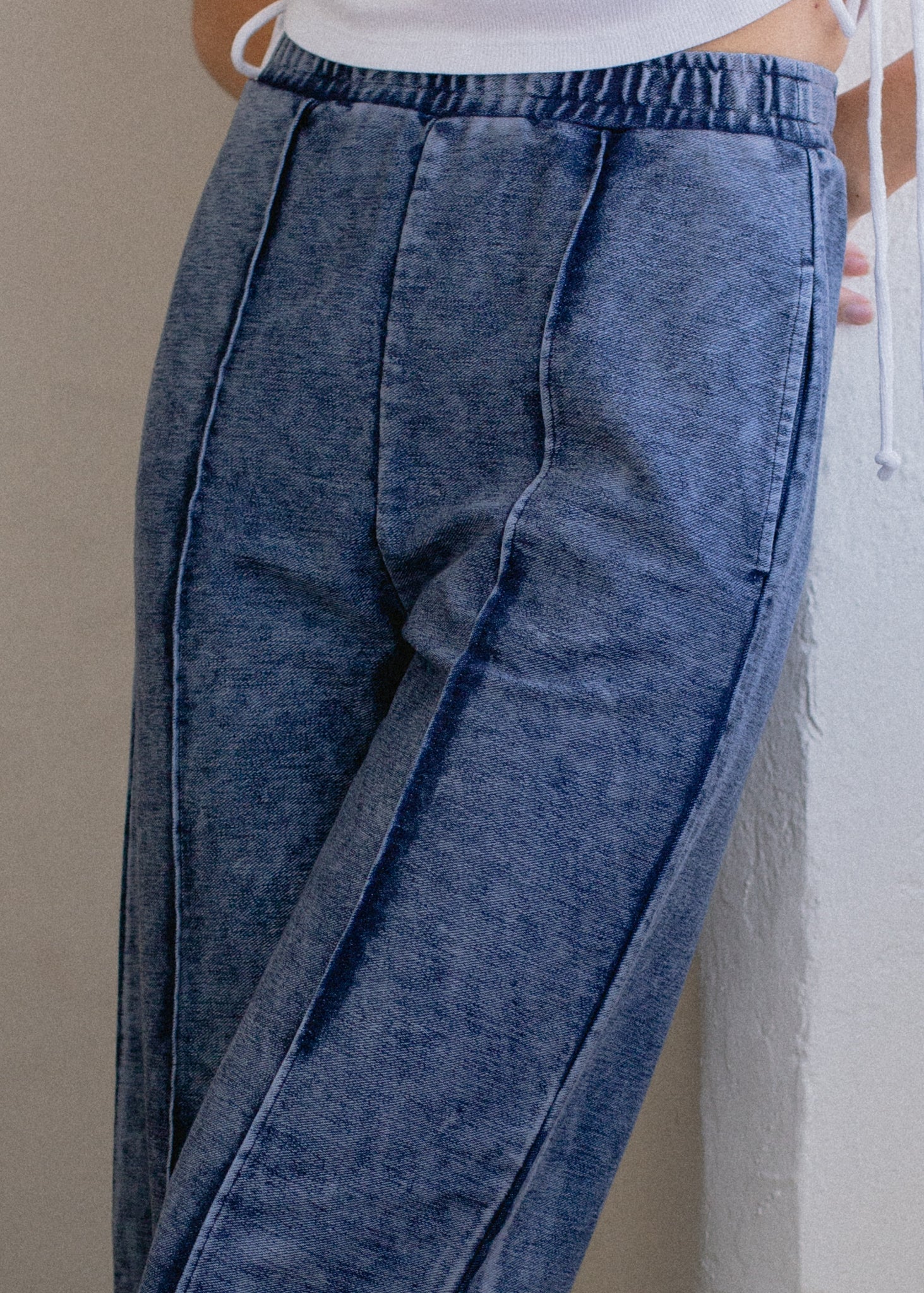 Blue denim pants worn by a person against a neutral background