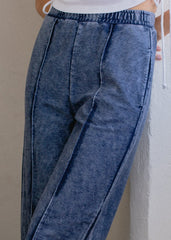Blue denim pants worn by a person against a neutral background