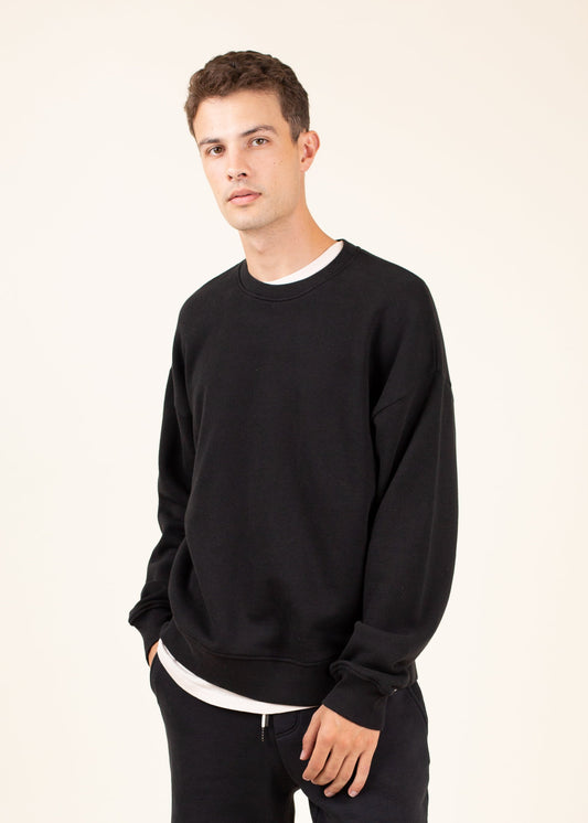 Man wearing a black sweatshirt on a beige background