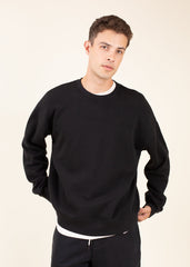 Man wearing a black sweatshirt on a beige background
