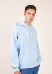 Man wearing a light blue hoodie against a plain background