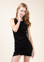 Woman wearing a black dress against a plain background