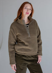 Person wearing a brown fleece pullover with a plain background