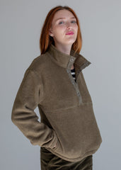 Woman wearing a brown fleece pullover against a plain background