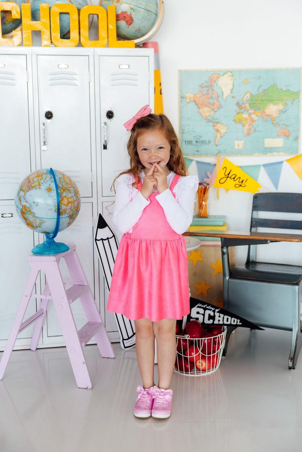 Young girl in a classroom setting with educational decor