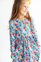 Young girl wearing a colorful floral dress on a white background