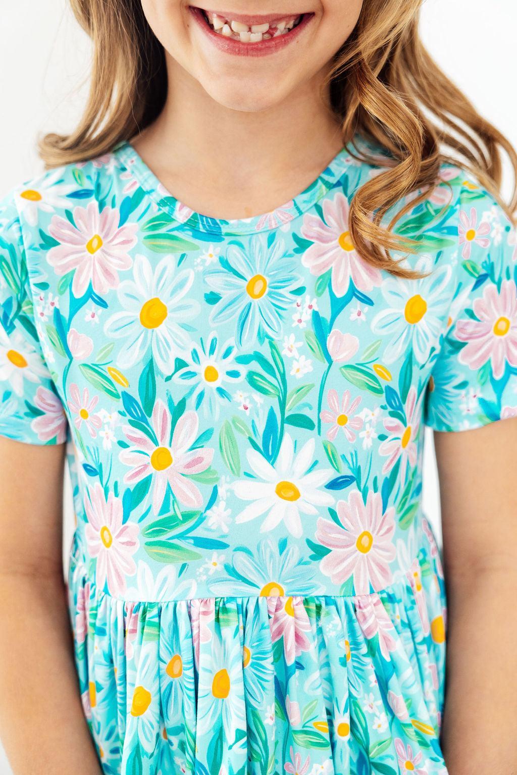 Child wearing a floral dress with a white background