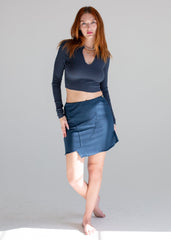 Woman wearing a blue top and skirt on a gray background