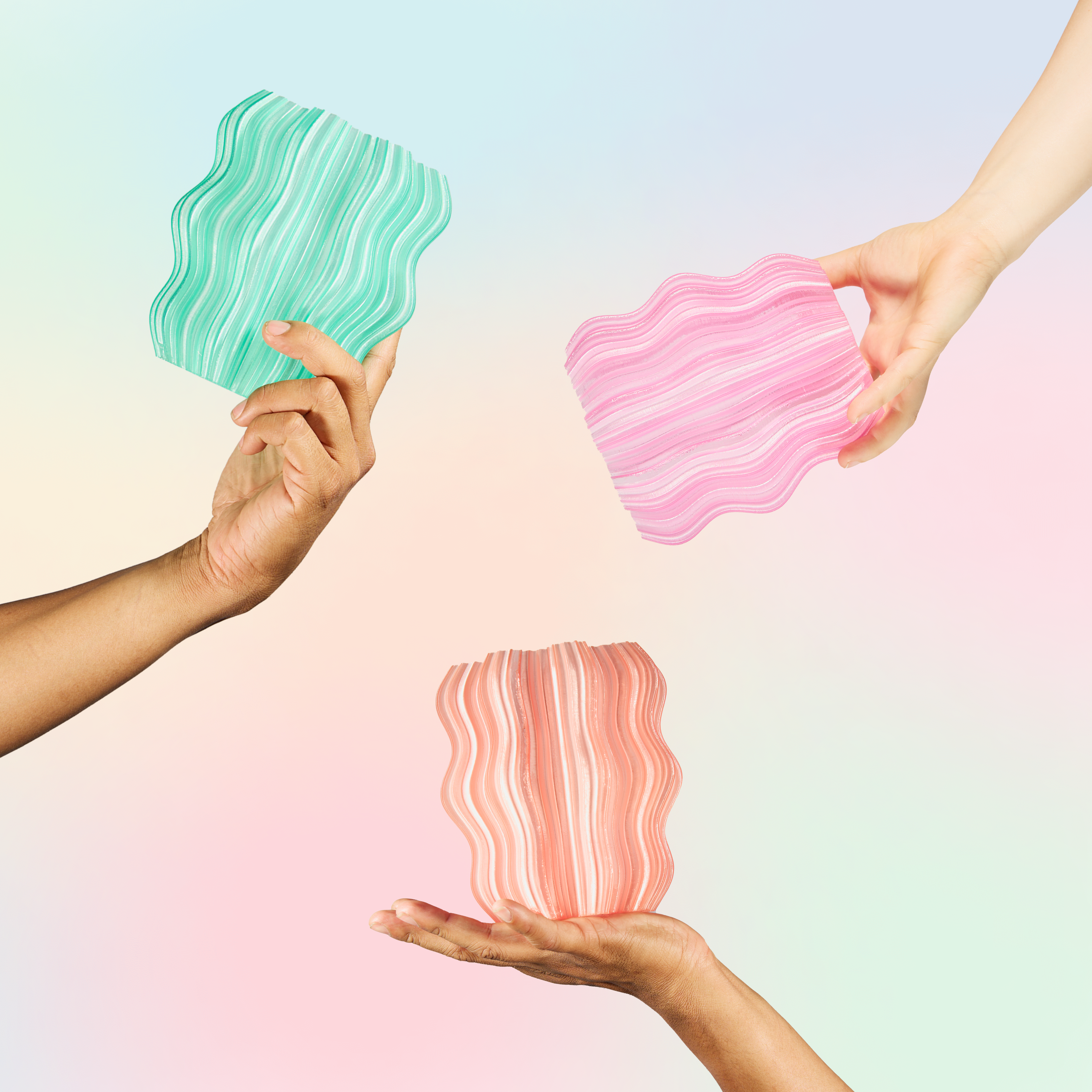 Three hands holding colorful, wavy-shaped objects against a gradient background