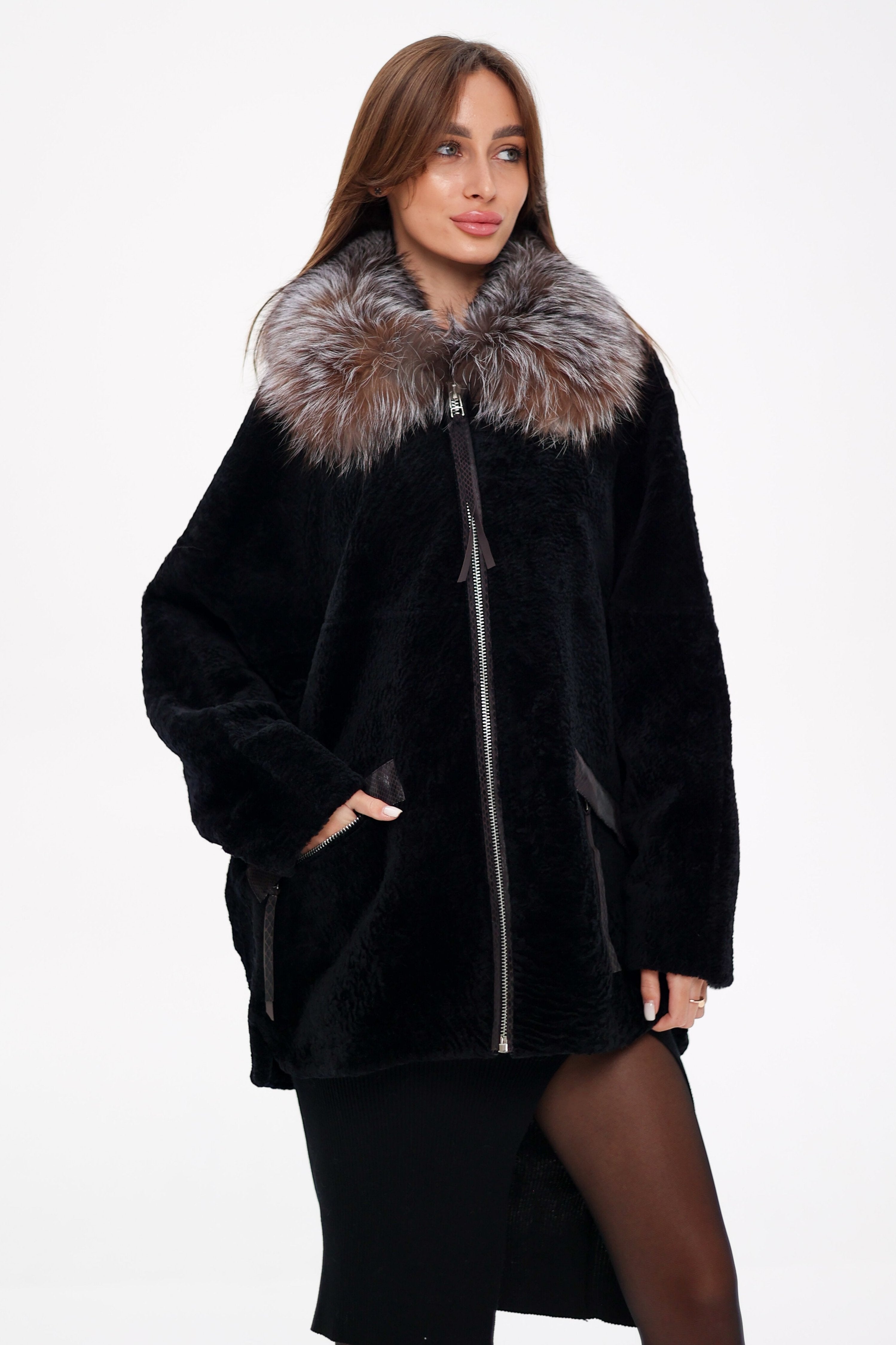Woman wearing a black coat with a fur collar on a white background