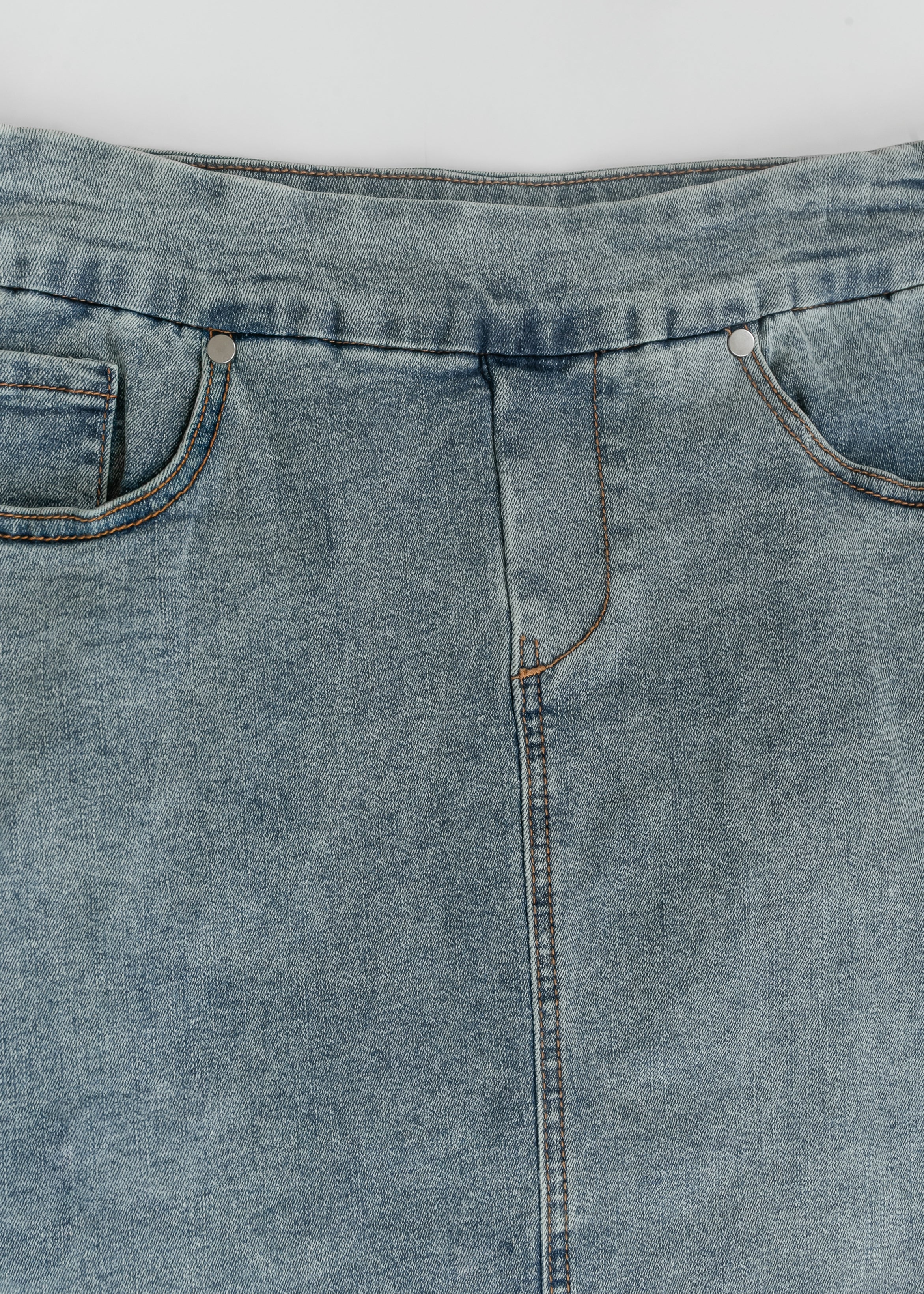 Close-up of blue denim jeans with a white background
