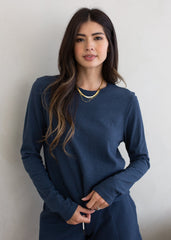 Woman wearing a navy blue outfit against a plain background