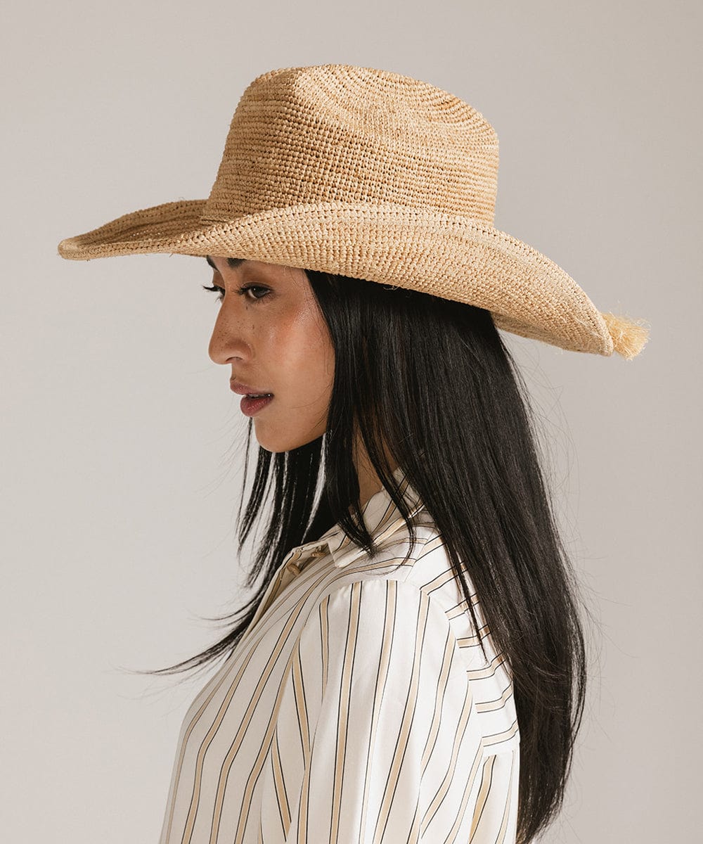 Woman wearing a straw hat against a plain background