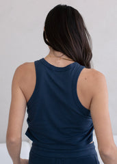 Person wearing a navy blue tank top against a plain background
