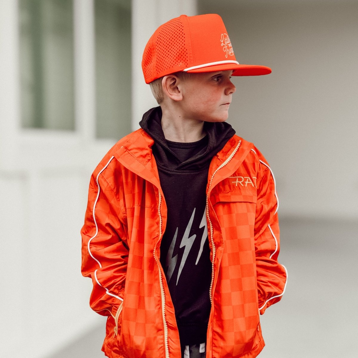 Person wearing an orange jacket and cap with a blurred background