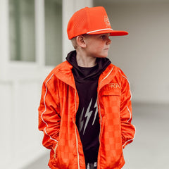 Person wearing an orange jacket and cap with a blurred background