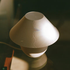 White ceramic vase with textured surface on a dark background