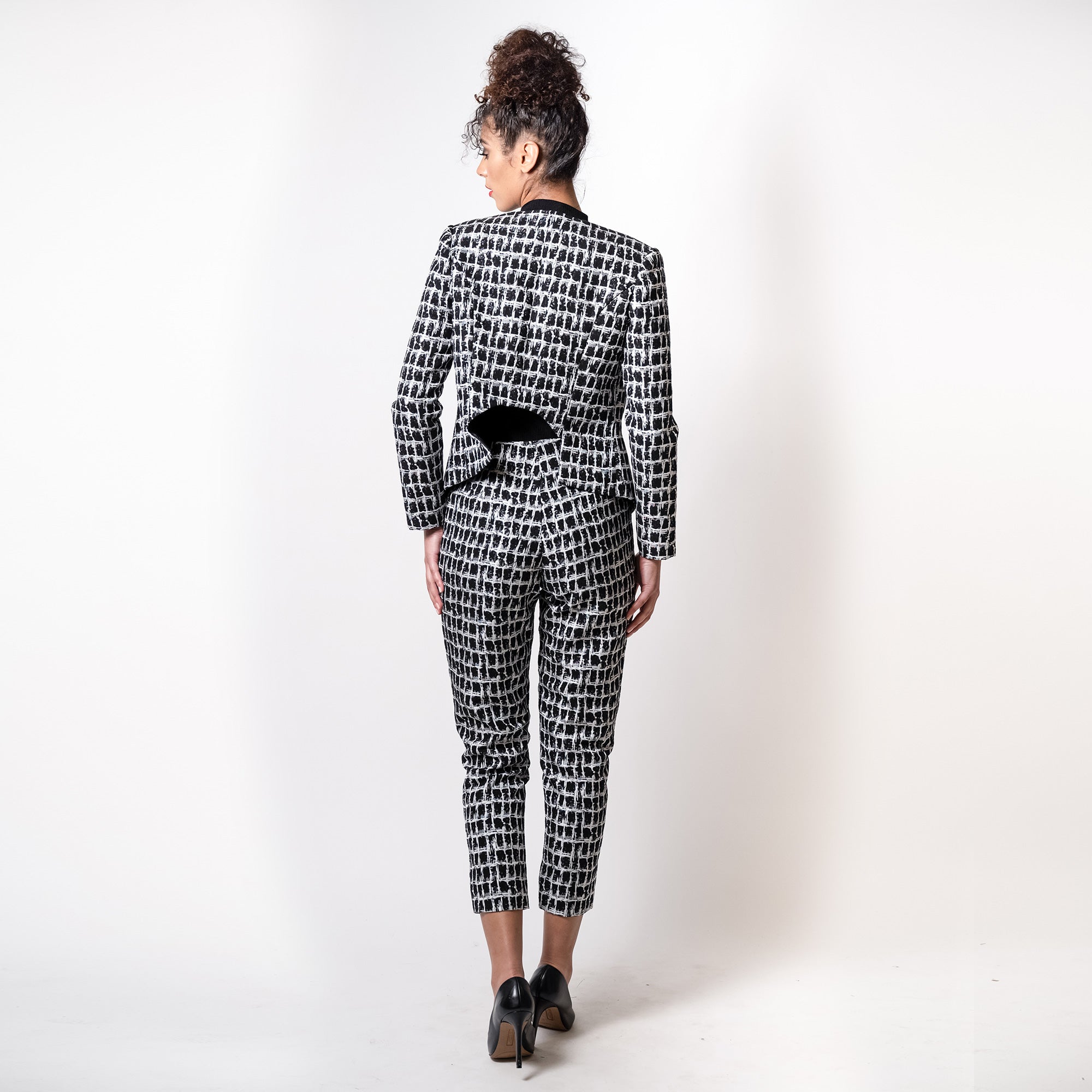 Person wearing a black and white patterned suit on a white background