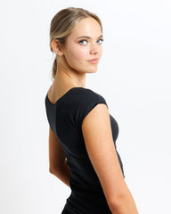 Woman wearing a black dress against a white background