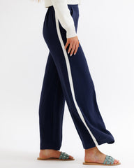 Navy pants with a white stripe worn by a person on a white background