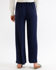 Navy wide-leg pants worn by a person on a white background