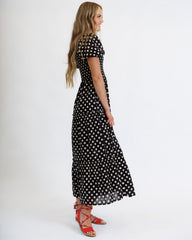 Woman wearing a black polka dot dress on a white background