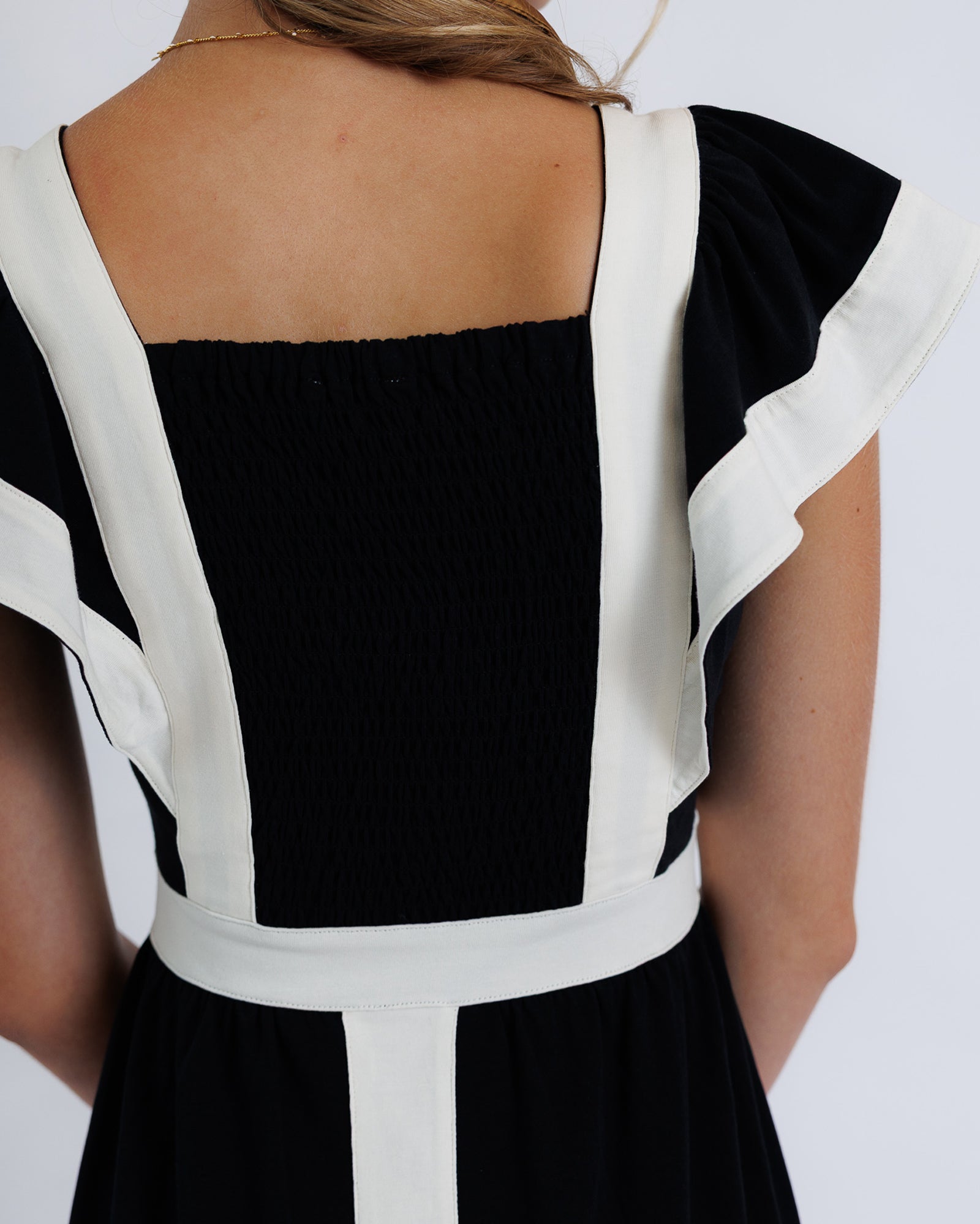 Black and white dress with ruffled sleeves on a plain background