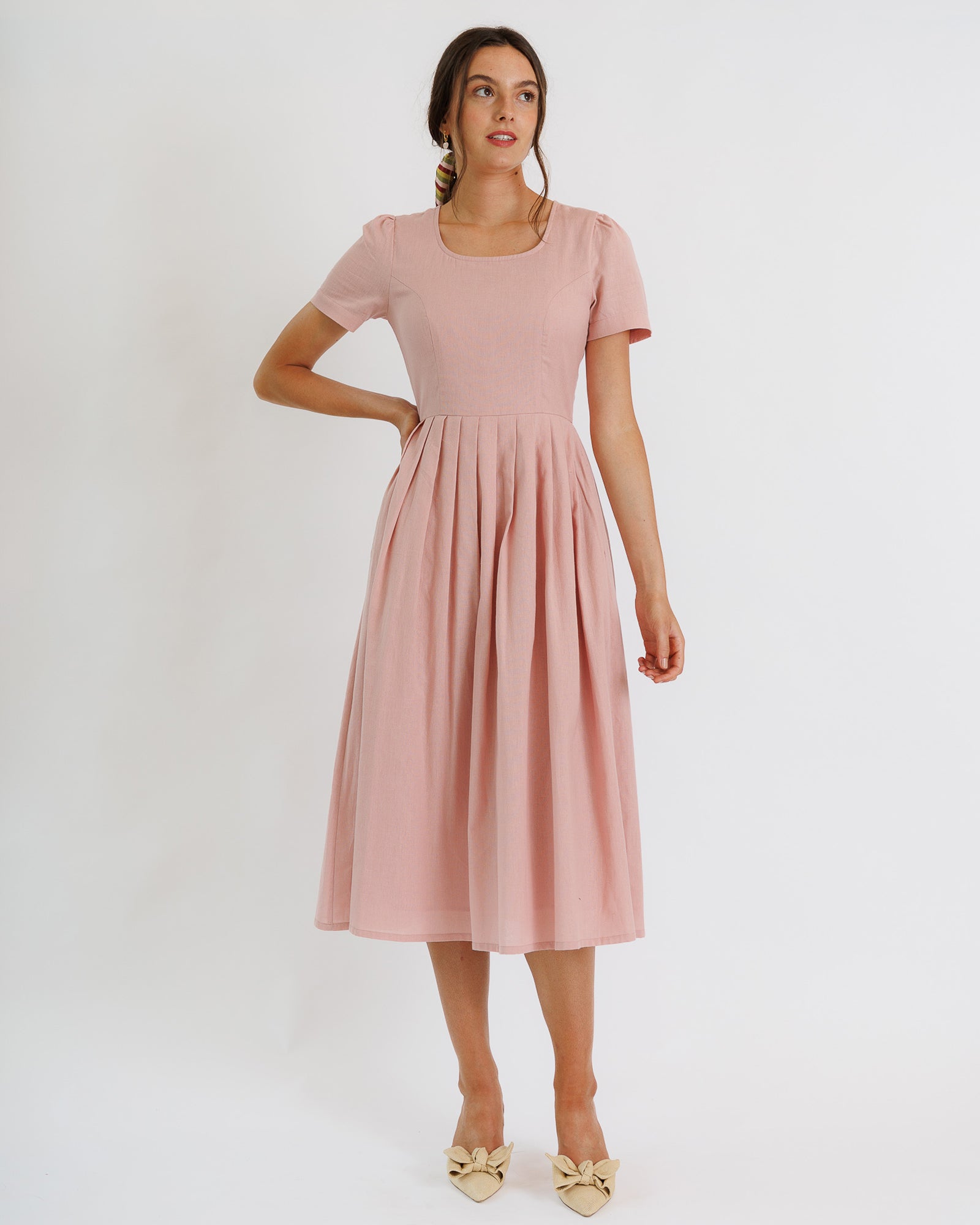 Woman wearing a pink dress on a white background