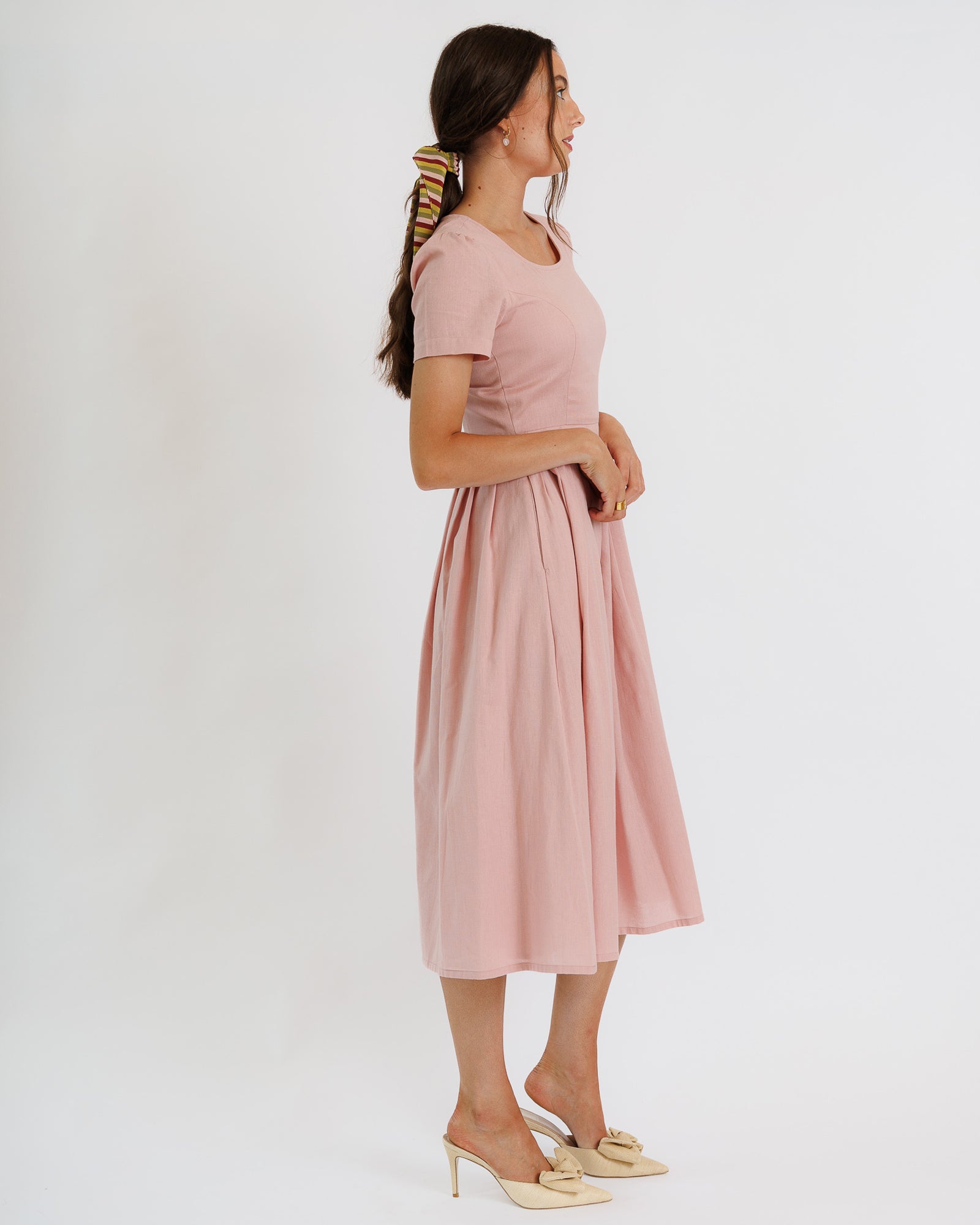 Woman wearing a pink dress on a white background