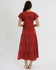Red tiered dress worn by a person on a white background