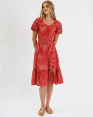 Woman wearing a red checkered dress on a white background