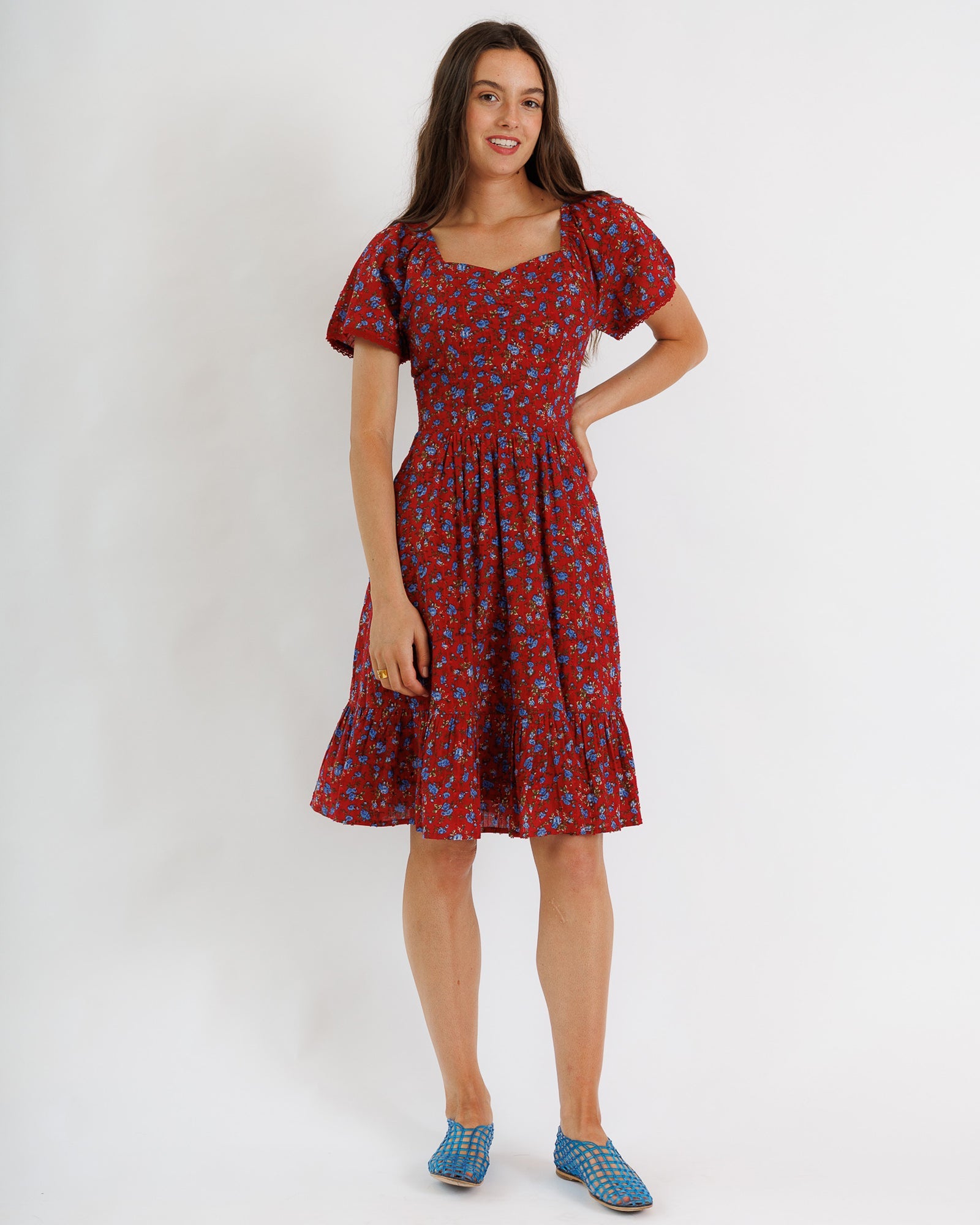 Woman wearing a red floral dress on a white background