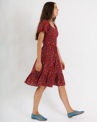 Woman wearing a red floral dress on a white background