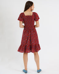 Woman wearing a red floral dress on a white background