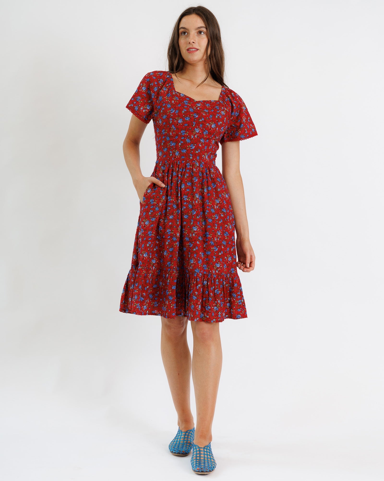 Woman wearing a red floral dress on a white background