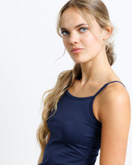 Woman wearing a navy blue tank top against a white background